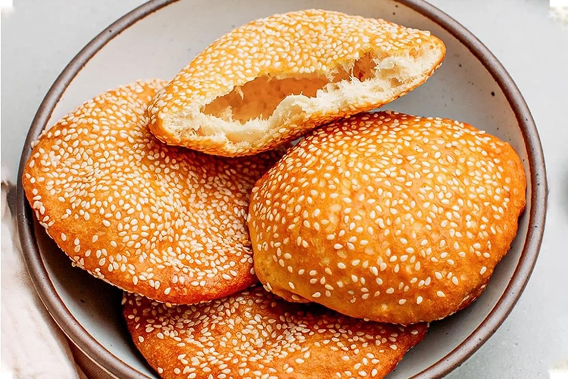 Golden-brown banh tieu with their characteristic hollow, balloon-like shape